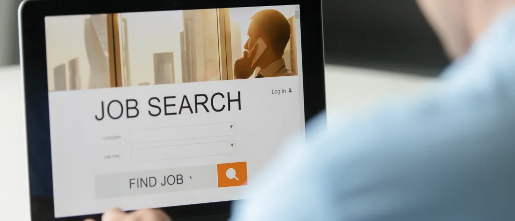 Person sitting at a laptop computer with a screen titled "Job Search"